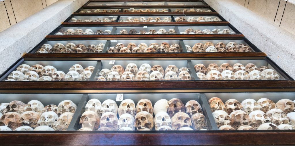 Display of human skulls in glass cases at the Killing Fields memorial in Cambodia.