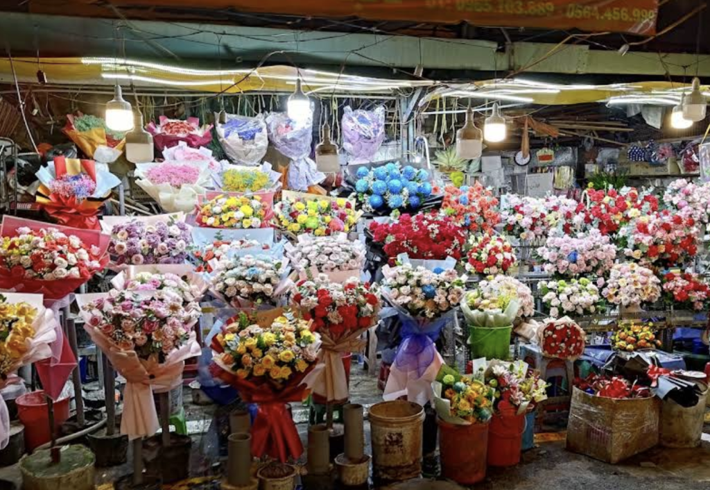 A vibrant display of colorful flower bouquets at Ho Thi Ky Market in Saigon, showcasing a variety of blooms wrapped in decorative paper.