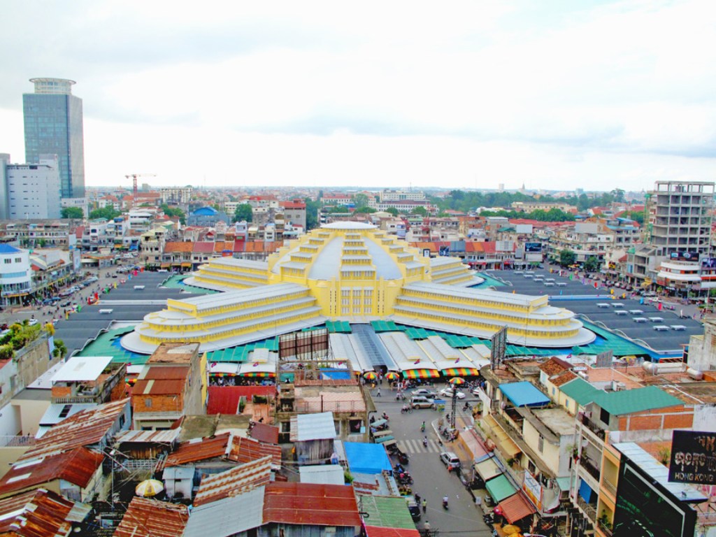 Aerial view of the Central Market (Phsar Thmey) in Phnom Penh, Cambodia, showcasing its iconic yellow dome and surrounding cityscape.