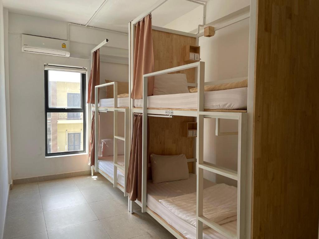 Interior of a modern hostel dormitory with bunk beds and natural light.