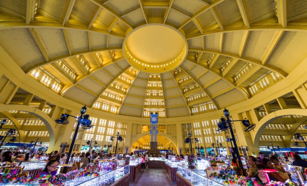 Interior view of the Central Market in Phnom Penh, showcasing its iconic yellow dome and bustling stalls filled with various goods.