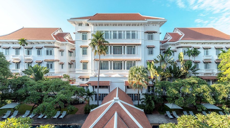 Exterior view of a luxurious hotel surrounded by greenery in Phnom Penh, Cambodia.