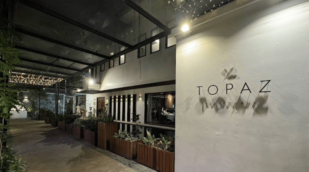 Entrance view of Topaz Restaurant in Phnom Penh, showcasing modern architectural design and ambient lighting.