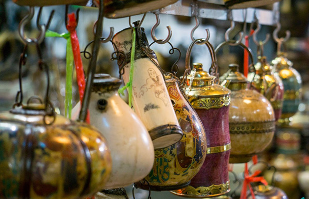 Colorful traditional ornaments and decorative items hanging in a market in Phnom Penh, showcasing intricate designs and craftsmanship.