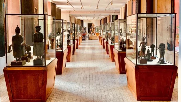 Interior view of the National Museum of Cambodia featuring display cases with various art pieces and sculptures.