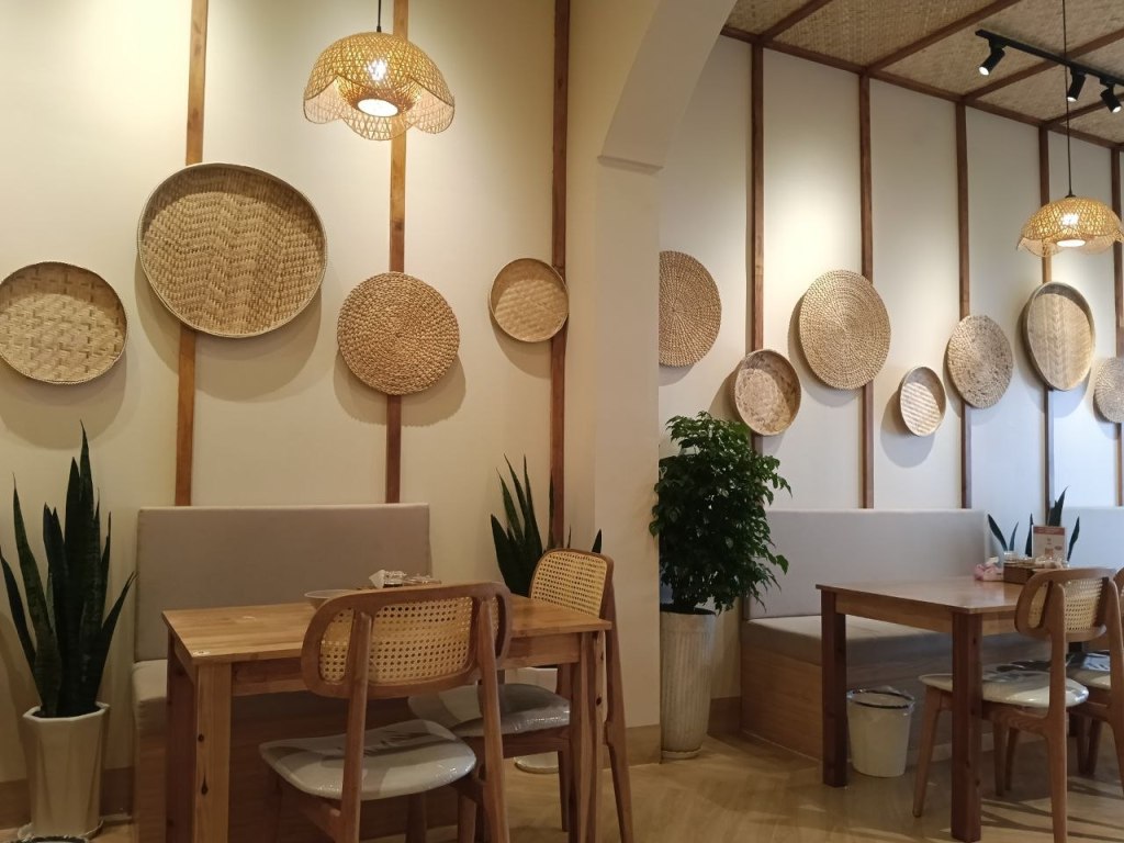 Cozy interior of Crab Shooting restaurant in Phnom Penh with rattan wall decor and wooden dining tables
