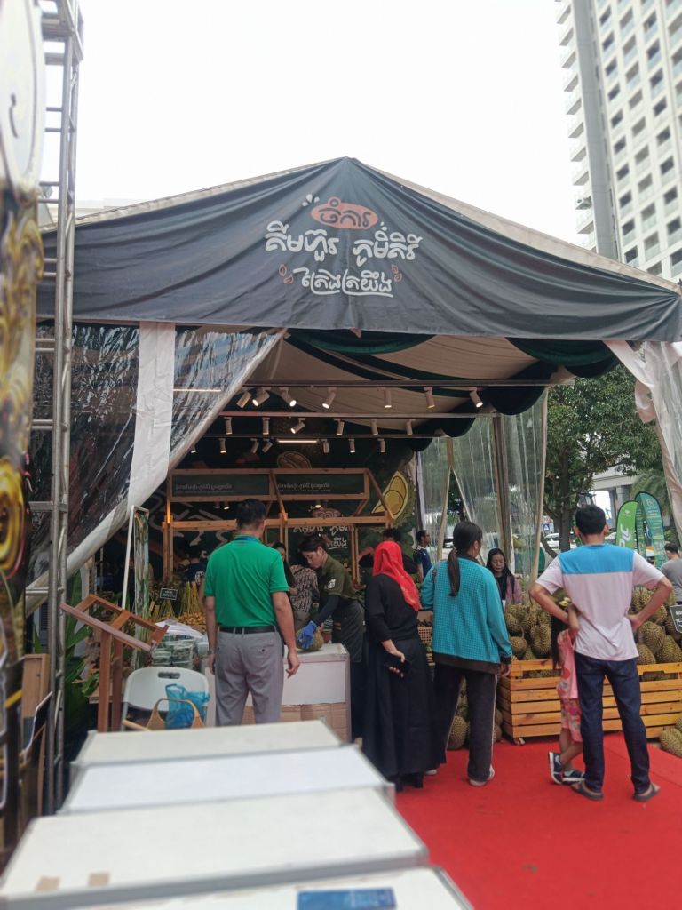 Visitors browsing stalls with fresh durians, fruits and local Cambodian products at the Khmer Food Must Be Strong exhibition at Koh Pich Theater 2026