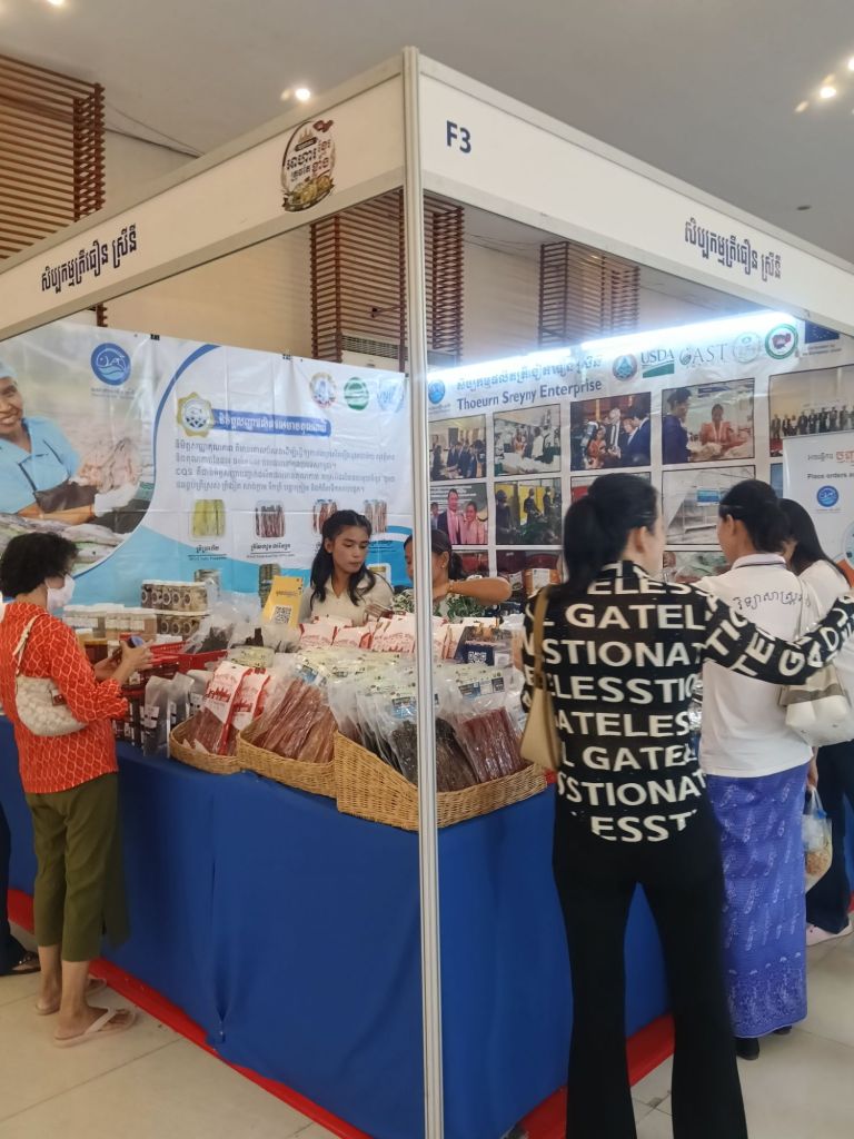 A visitor browsing dried fish and fish craft products at the Thuen SreyNy Fish Craft stall at the Khmer Food Must Be Strong exhibition at Koh Pich Theater 2026